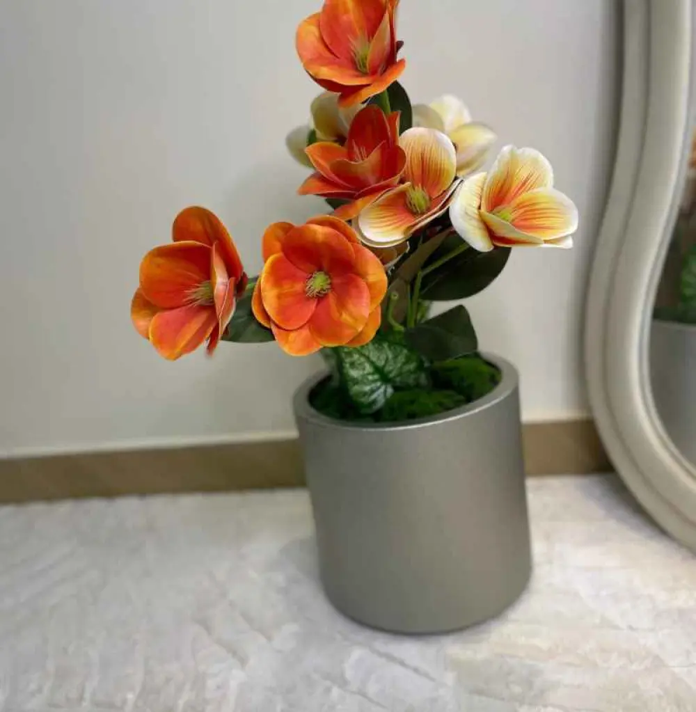 Vase décorative : arrangement floral artificiel dans un pot décoratif.
