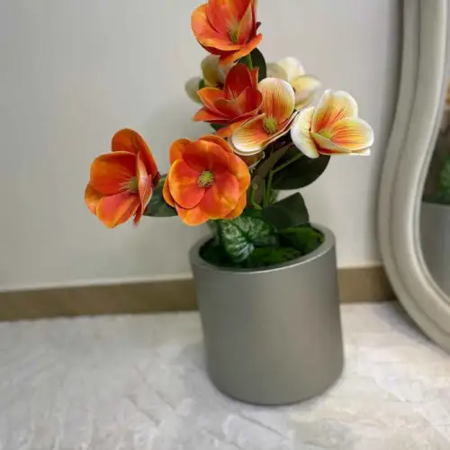 Vase décorative : arrangement floral artificiel dans un pot décoratif.